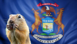 Michigan gopher eating in front of Michigan flag