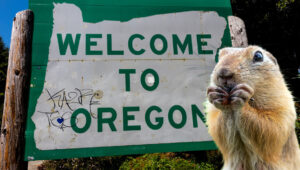 Gopher standing in front of Oregon Welcome sign